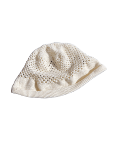 The image shows a handmade white crocheted summer hat. The crown features a breathable lace-like pattern, allowing ventilation, while the brim is more tightly stitched to ensure a secure fit. The hat is lightweight and feminine – perfect for sunny days